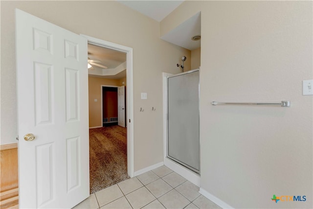 bathroom featuring tile patterned flooring, ceiling fan, and a shower with shower door