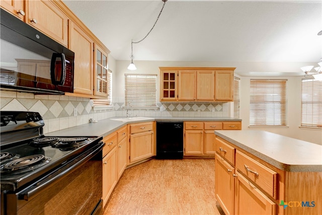 kitchen featuring pendant lighting, light hardwood / wood-style floors, black appliances, and backsplash