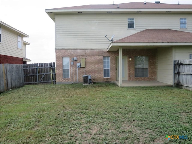 back of house with a yard, a patio area, and central air condition unit