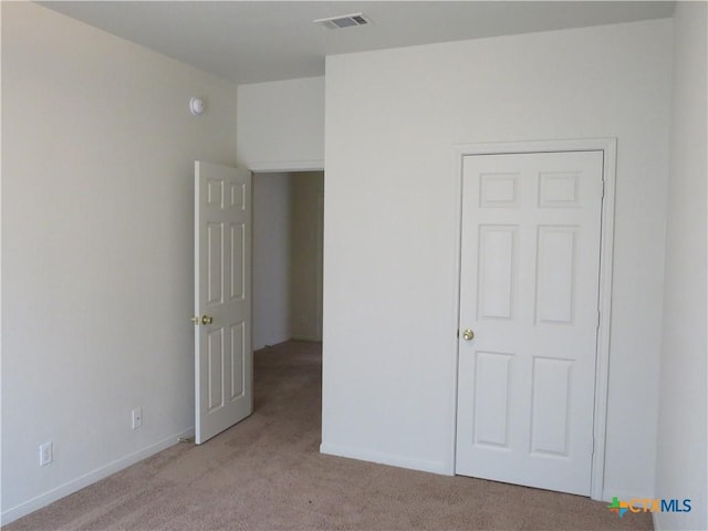 unfurnished bedroom featuring light carpet