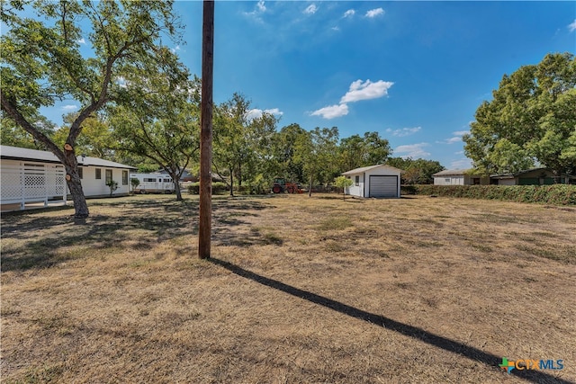 view of yard featuring a garage and an outdoor structure