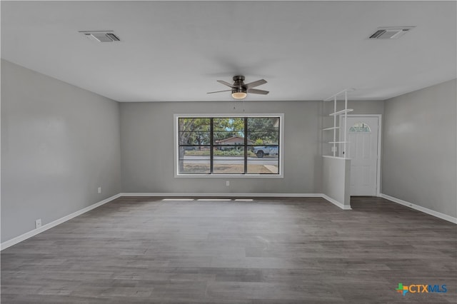 spare room featuring dark wood-type flooring and ceiling fan