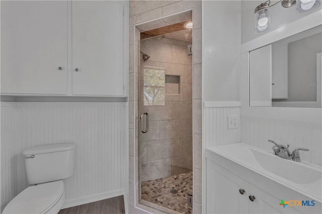 bathroom with hardwood / wood-style floors, an enclosed shower, vanity, and toilet