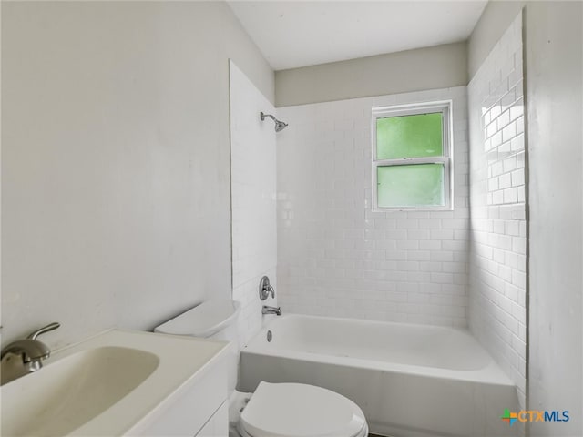 full bathroom with vanity, tiled shower / bath combo, and toilet