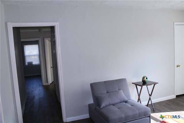 sitting room with dark hardwood / wood-style flooring and a textured ceiling