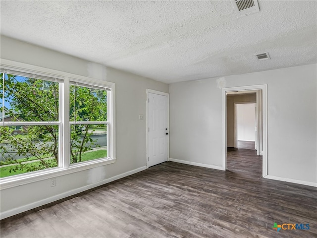 unfurnished room featuring a textured ceiling and dark hardwood / wood-style flooring