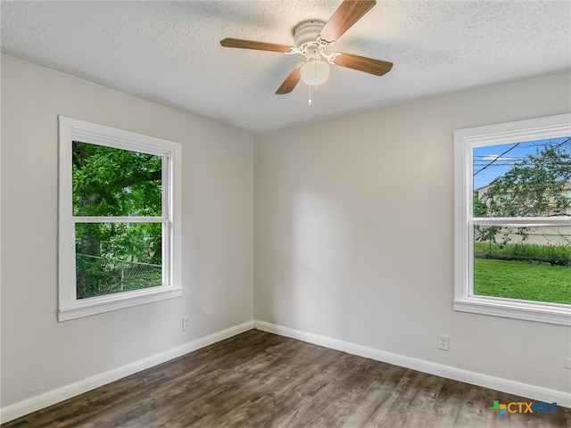 empty room featuring a textured ceiling, ceiling fan, and dark wood-type flooring