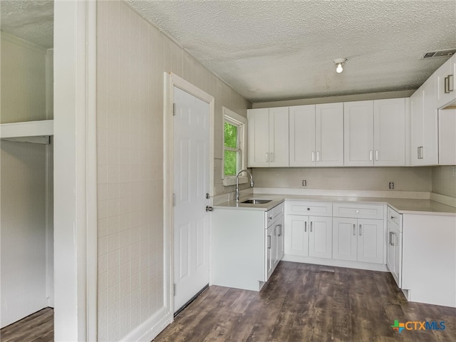 kitchen featuring dark hardwood / wood-style floors, white cabinetry, and sink