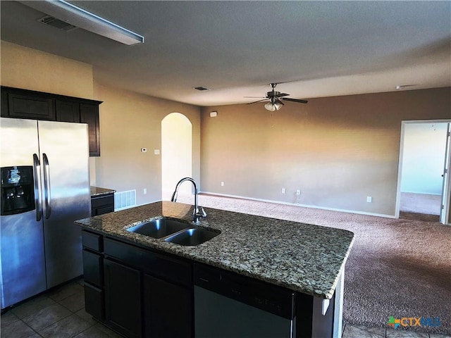 kitchen featuring stainless steel refrigerator with ice dispenser, dishwashing machine, ceiling fan, sink, and an island with sink