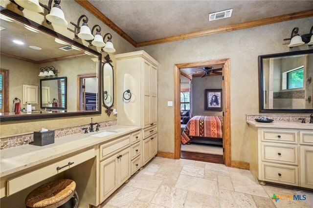 27302 Felswand Pkwy, New Braunfels, TX 78132 - ensuite bathroom featuring crown molding, a ceiling fan, stone tile floors, a textured wall, and vanity