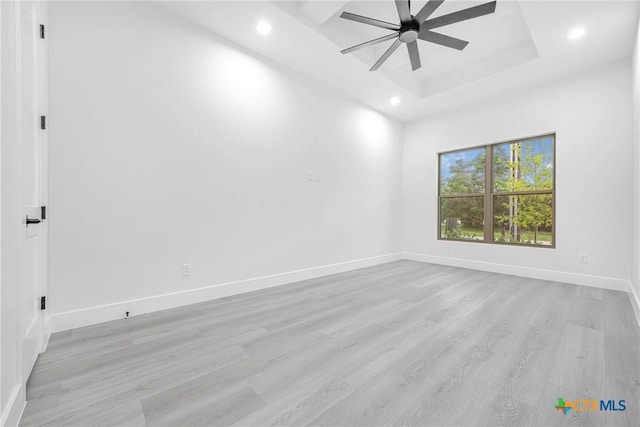 303 W Lane Ave, Manor, TX 78653 - spare room with a ceiling fan, recessed lighting, light wood-style floors, and a tray ceiling