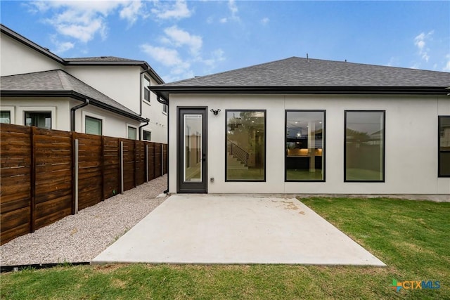 303 W Lane Ave, Manor, TX 78653 - rear view of property with a fenced backyard, a patio area, roof with shingles, and stucco siding