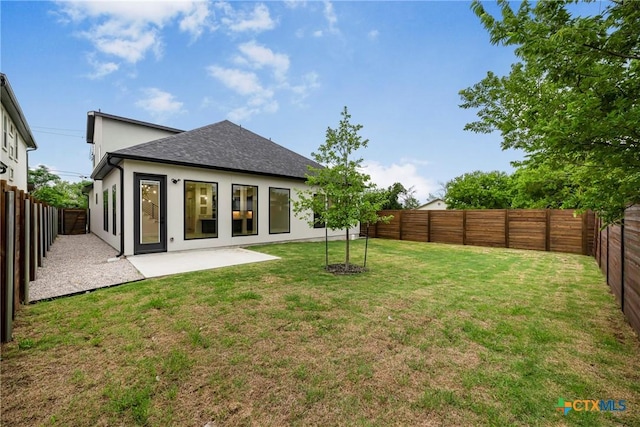 303 W Lane Ave, Manor, TX 78653 - back of property with a fenced backyard, roof with shingles, stucco siding, and a patio area