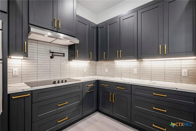 303 W Lane Ave, Manor, TX 78653 - kitchen featuring under cabinet range hood, black electric stovetop, backsplash, and light stone counters