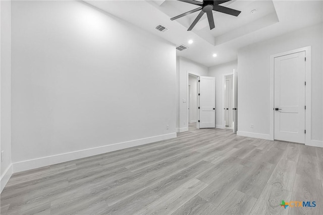 303 W Lane Ave, Manor, TX 78653 - unfurnished bedroom featuring recessed lighting, light wood-style floors, a raised ceiling, and a ceiling fan
