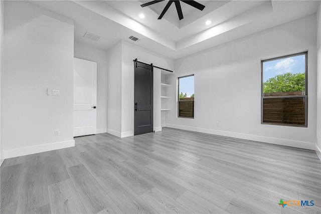 303 W Lane Ave, Manor, TX 78653 - empty room with a barn door, plenty of natural light, ceiling fan, light wood finished floors, and recessed lighting