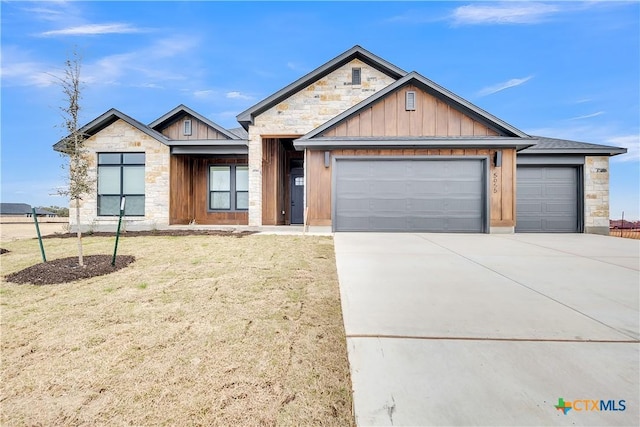 view of front of home with a garage, stone siding, board and batten siding, and concrete driveway