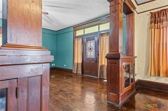 9 S Milam St, Rogers, TX 76569 - foyer entrance featuring crown molding, a textured ceiling, baseboards, and wood finished floors