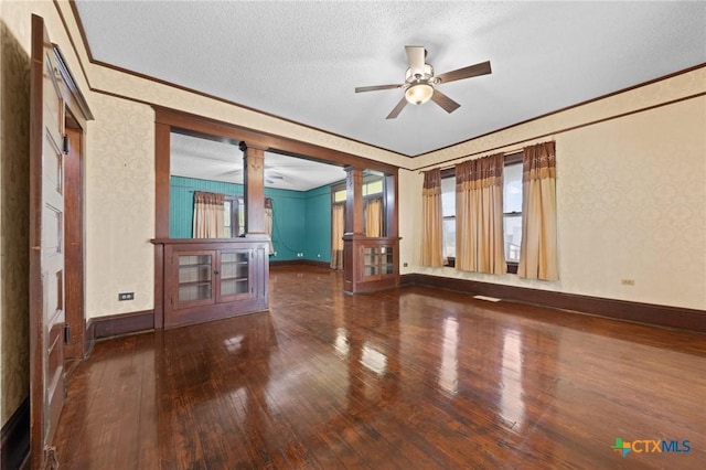 9 S Milam St, Rogers, TX 76569 - spare room featuring crown molding, hardwood / wood-style flooring, ornate columns, and a ceiling fan