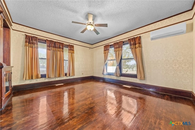 9 S Milam St, Rogers, TX 76569 - spare room with a ceiling fan, a wall unit AC, plenty of natural light, baseboards, and hardwood / wood-style flooring