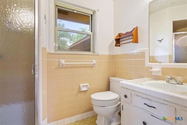 4412 Briar Cliff Rd, Temple, TX 76502 - full bathroom featuring a shower stall, tile walls, vanity, toilet, and a wainscoted wall