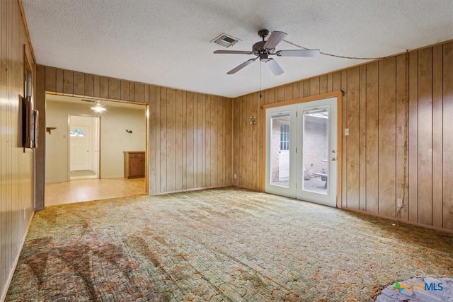 4412 Briar Cliff Rd, Temple, TX 76502 - carpeted empty room featuring wooden walls, a ceiling fan, and a textured ceiling