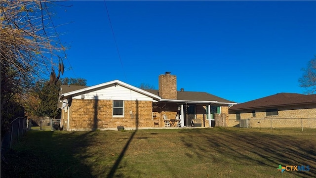 rear view of house featuring a yard and central AC