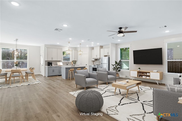 living room with light hardwood / wood-style floors and ceiling fan