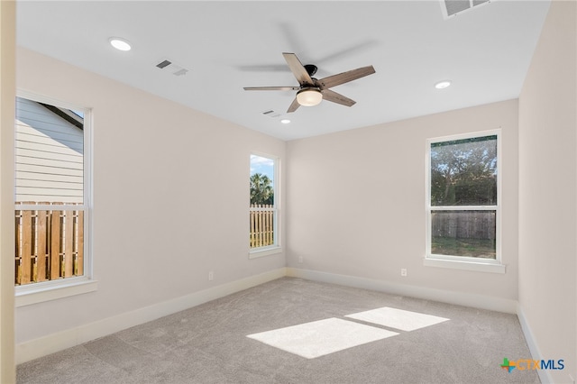 spare room featuring light colored carpet and ceiling fan