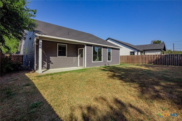 rear view of house featuring a lawn