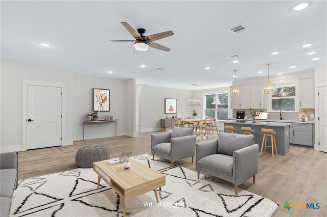 living room with light wood-type flooring and ceiling fan