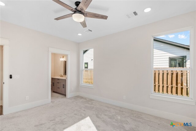 unfurnished bedroom with light carpet, ceiling fan, and ensuite bathroom