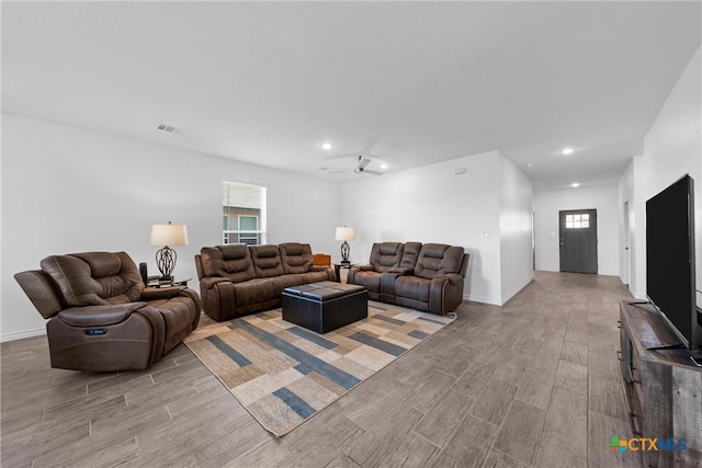 living area with visible vents, a healthy amount of sunlight, and wood finish floors