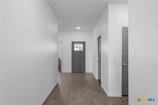 hall with wood finished floors and baseboards