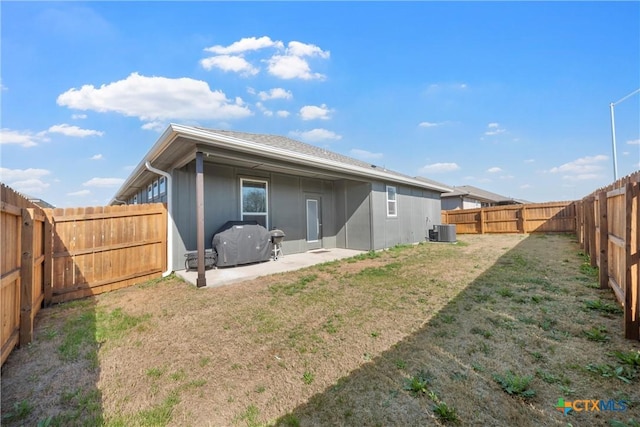 back of house featuring central air condition unit, a patio, a yard, and a fenced backyard