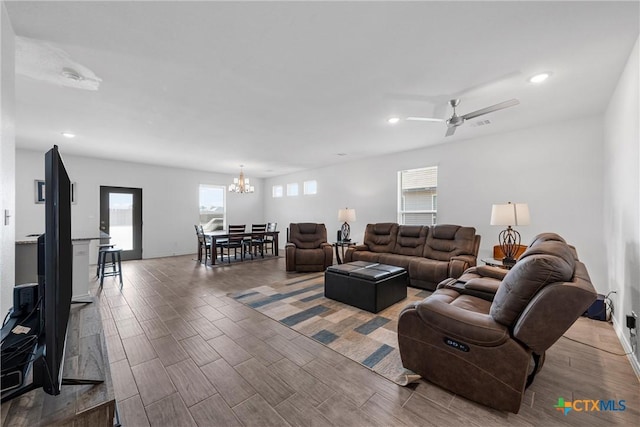 living room featuring recessed lighting, ceiling fan with notable chandelier, and wood tiled floor