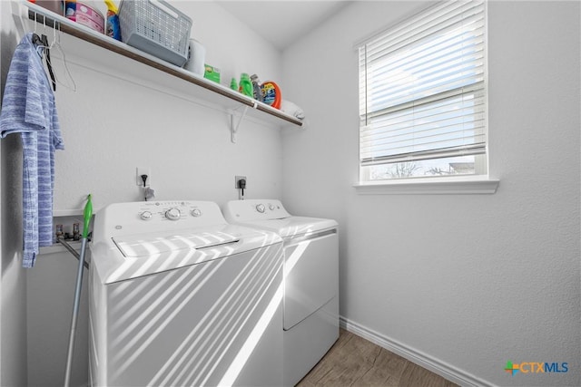 laundry room with laundry area, independent washer and dryer, light wood-style flooring, and baseboards