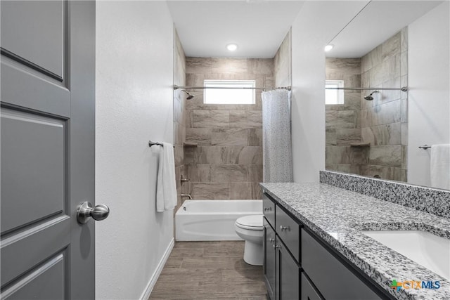 full bathroom featuring baseboards, toilet, wood finished floors, shower / bath combination with curtain, and vanity