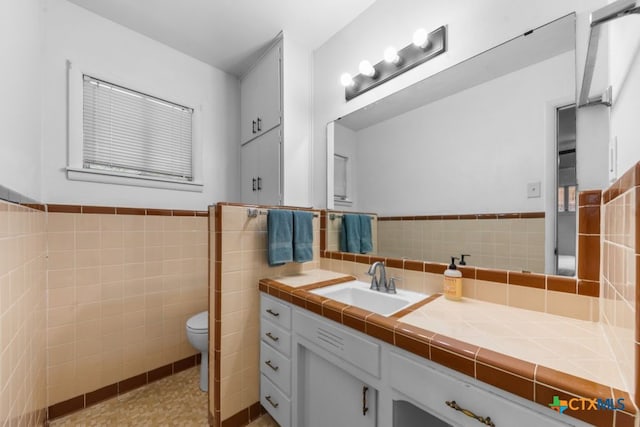 3113 W Ave T, Temple, TX 76504 - bathroom featuring tile walls, vanity, toilet, and a wainscoted wall