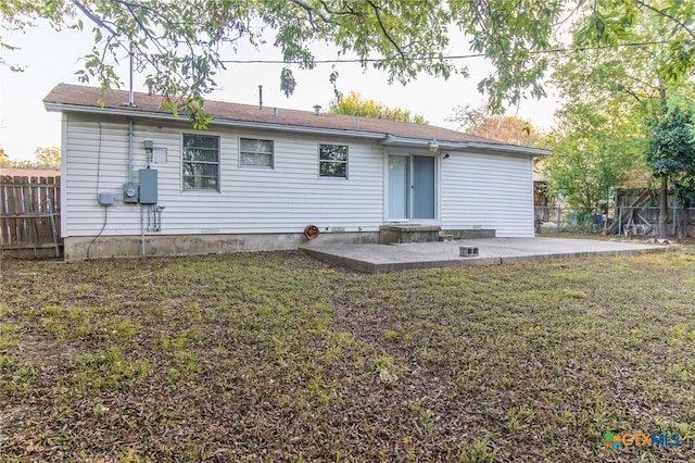 back of property with a patio area and a yard