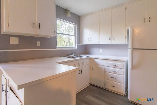 kitchen featuring white cabinets, white refrigerator, dark hardwood / wood-style flooring, and sink