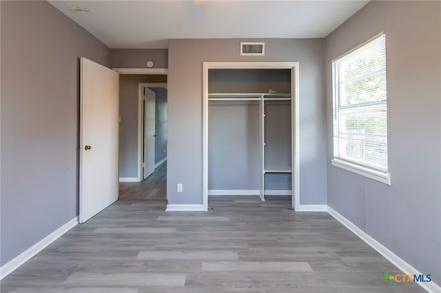 unfurnished bedroom featuring light hardwood / wood-style floors and a closet