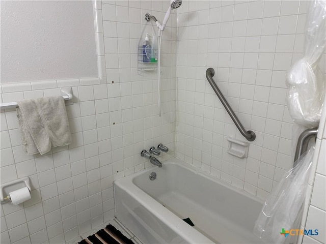 bathroom featuring tile walls and shower / tub combo