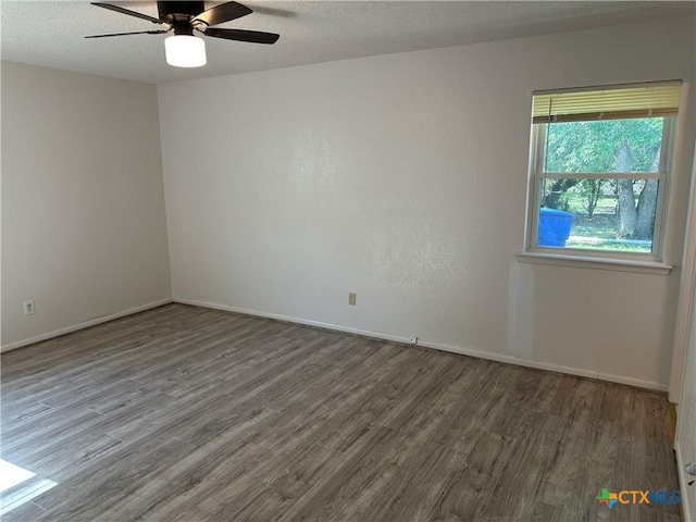 empty room with baseboards, ceiling fan, and wood finished floors