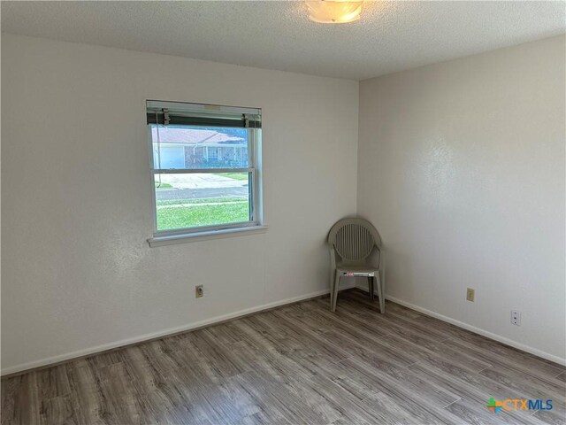 908 Randa St, Copperas Cove, TX 76522 - empty room with baseboards, a textured ceiling, and wood finished floors
