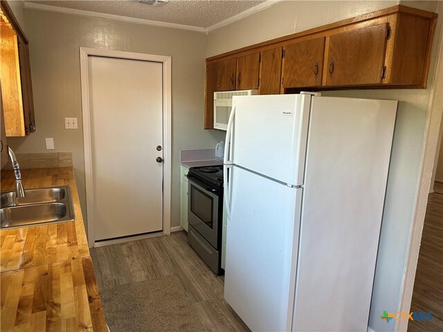 908 Randa St, Copperas Cove, TX 76522 - kitchen featuring a sink, white appliances, brown cabinetry, wood finished floors, and ornamental molding