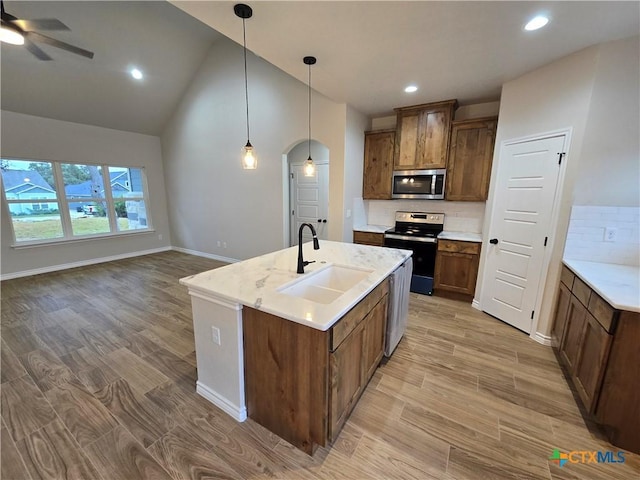 kitchen featuring hanging light fixtures, light hardwood / wood-style floors, sink, and appliances with stainless steel finishes