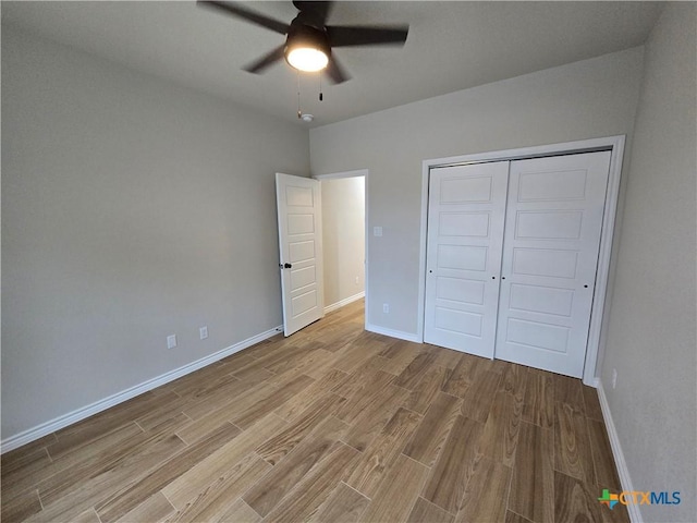 unfurnished bedroom with a closet, light hardwood / wood-style floors, and ceiling fan