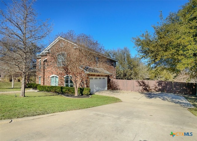 view of front facade with driveway, fence, a front lawn, and brick siding