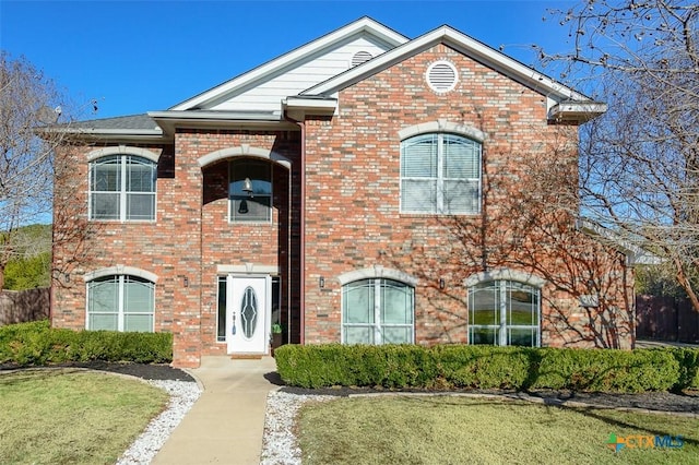 view of front facade featuring a front yard and brick siding